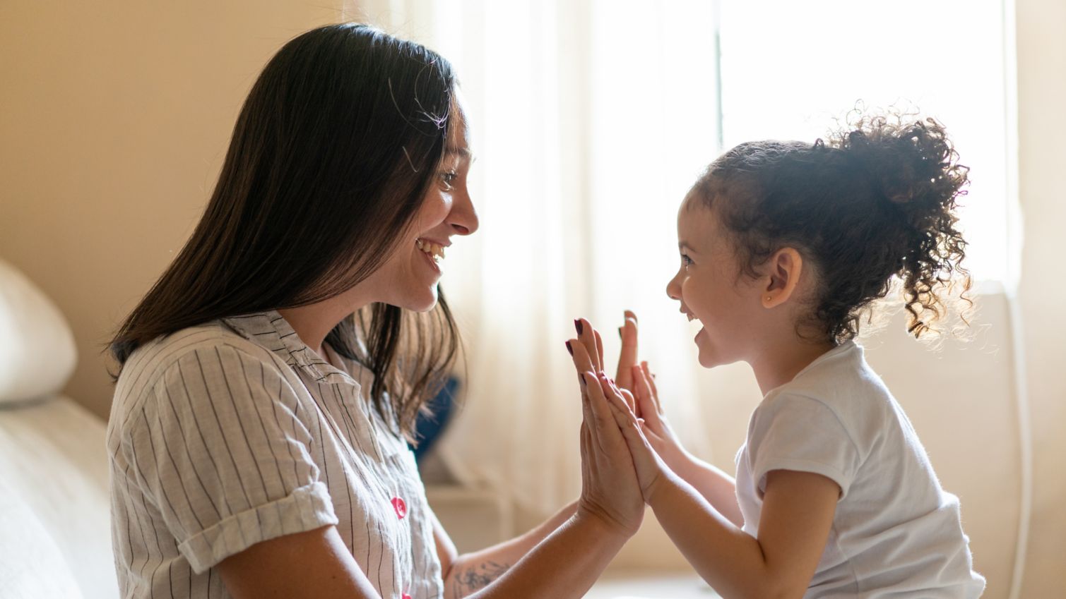 Mom plays patty-cake with daughter